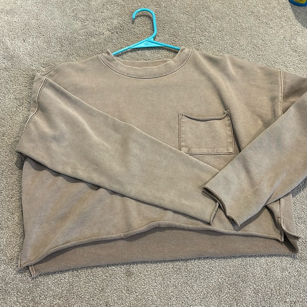 Basic tan crop top with pocket on left side.
